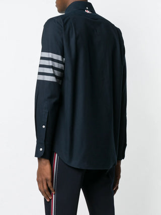 THOM BROWNE straight fit shirt. Oxford or chambray with signature 4-Bar stripe, patch pocket, and name tag patch. Available at our Lisbon store. 