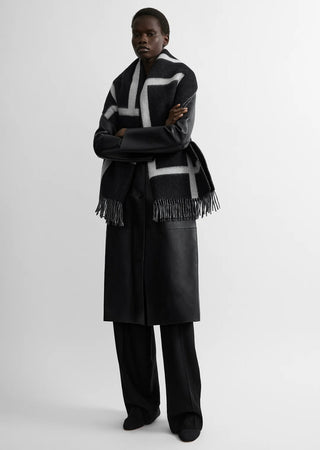 Scarf crafted in Italy from brushed wool, finished with a monogram and contrasting fringe. A classic piece that layers easily over winter outerwear.