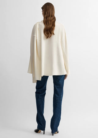 Blouse crafted from fluid viscose cady with elongated sleeves. Juxtapose the draped silhouette with denim, heels and a clutch. Available at our Lisbon store. 