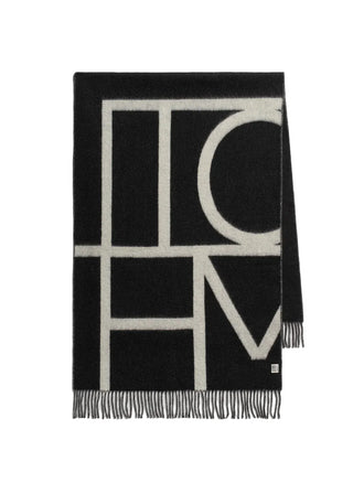 Scarf crafted in Italy from brushed wool, finished with a monogram and contrasting fringe. A classic piece that layers easily over winter outerwear.