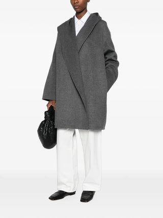 TOTEME grey wool hooded coat. A relaxed, oversized silhouette in 100% wool with an open front. Available at our Lisbon store. 