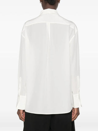 TOTEME's silk crepe shirt. Luxuriously fluid, with a relaxed fit and subtle sheen. Effortless elegance for any wardrobe. Available at our Lisbon store. 