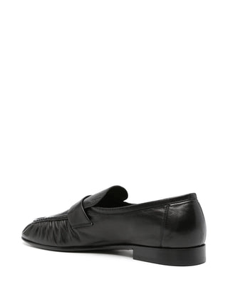 Almond-toe loafer by The Row. Soft nappa leather apron front with a block heel. Refined minimalism with a debossed branded insole. Available at our Lisbon store