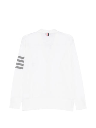 Thom Browne white Classic V-neck cardigan with grey stripes, button fastening and front pockets. Refined everyday layer. Available at our Lisbon store.