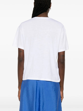 Person wearing a white t-shirt and blue skirt by Toteme