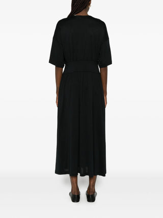 Person wearing a black dress by Toteme