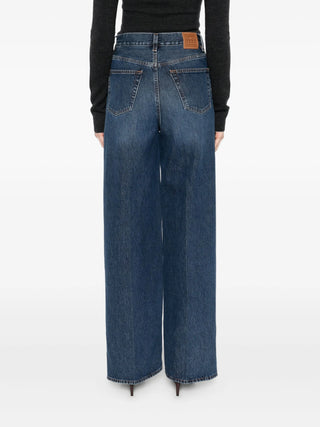 Blue jeans with wide-legs worn by a person 
