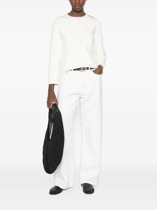 TOTEME's classic compact knit cardigan in white. Clean lines, pearl buttons, and a refined silhouette. A timeless layering piece. Available at our Lisbon store.