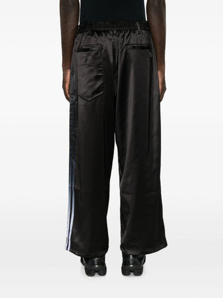 Y-3 drawstring satin trousers. A luxe silhouette with gradient side stripes, D-ring, and a drawstring waist. Available at our Lisbon store.