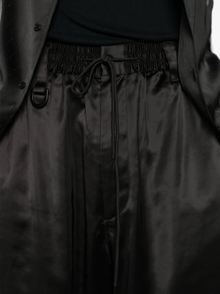 Y-3 drawstring satin trousers. A luxe silhouette with gradient side stripes, D-ring, and a drawstring waist. Available at our Lisbon store.