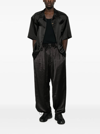 Y-3 drawstring satin trousers. A luxe silhouette with gradient side stripes, D-ring, and a drawstring waist. Available at our Lisbon store.