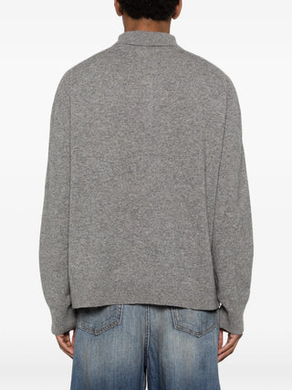 Person wearing a gray sweater and blue jeans by Acne Studios