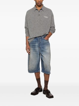 Person wearing a gray polo shirt and blue jeans by Acne Studios