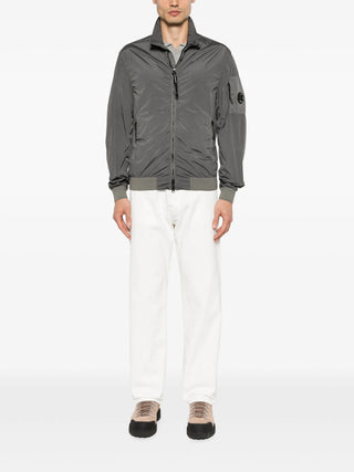 C.P. Company short jacket in Nycra-R. Crafted from ECONYL® regenerated stretch nylon with iconic lens detail. Garment dyed. Regular fit. 