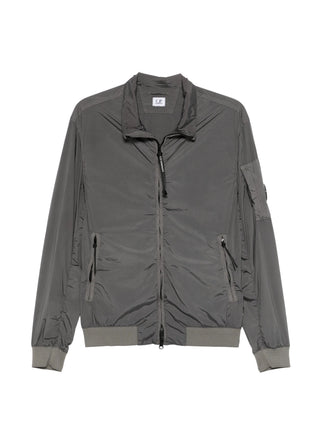 C.P. Company short jacket in Nycra-R. Crafted from ECONYL® regenerated stretch nylon with iconic lens detail. Garment dyed. Regular fit. 