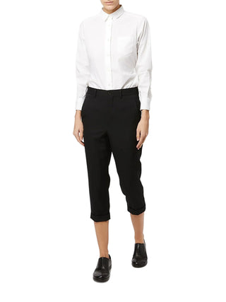 Person wearing a white shirt with Black cropped trousers by Comme des Garcons with black shoes