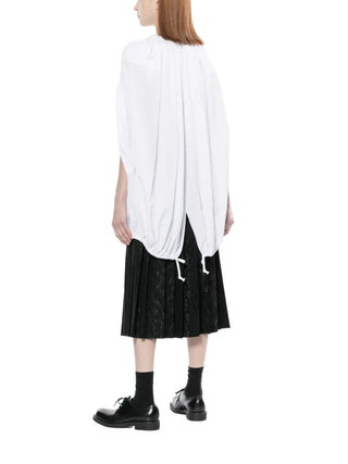 White gathered blouse worn with black skirt and shoes