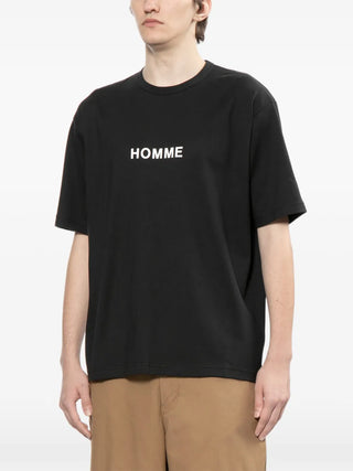 Person wearing a black t-shirt with 'HOMME' text 