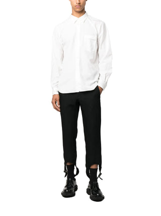 White long sleeve shirt by comme des garcons homme plus worn with black pants and black shoes. 