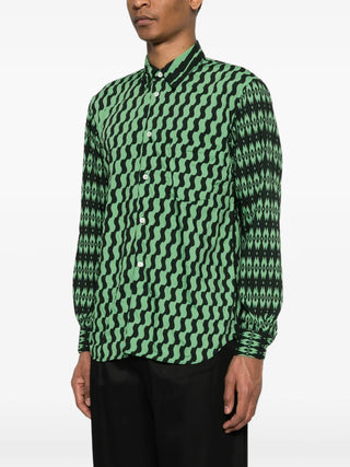 Person wearing a green and black patterned shirt on a white background