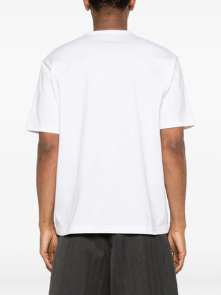Person wearing a plain white t-shirt by Comme Des Garcons Homme Plus