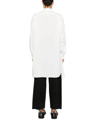 Person wearing a white shirt and black pants by Comme des Garcons Homme Plus