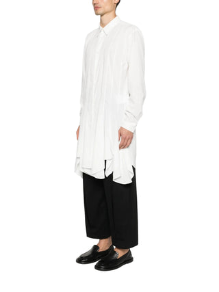 Person wearing a white shirt and black pants on a white background