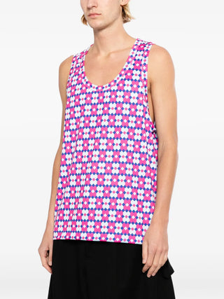 Person wearing a sleeveless geometric patterned top on a white background
