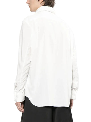 Person wearing a white shirt with a blurred background