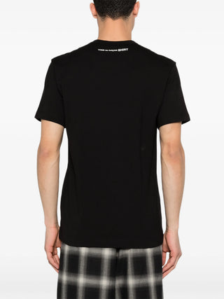 Person wearing a black t-shirt with text on the back