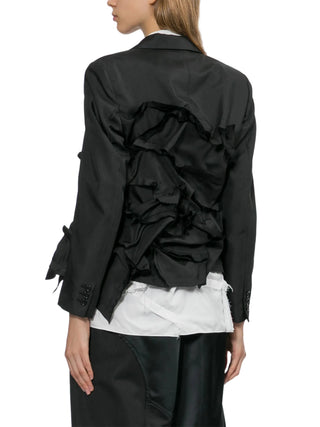 Black ruffled jacket over a white shirt by Commes des Garcons