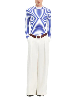 Person wearing a blue and white striped sweater with wide-leg white pants