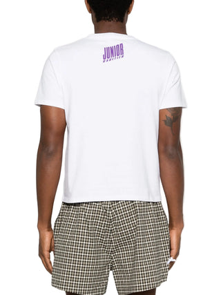 Person wearing a white t-shirt with 'Junior' printed on the back, paired with plaid shorts.