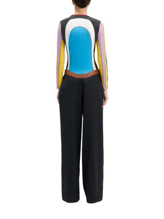 Person wearing a colorful long-sleeve top with a blue torso and black pants by Jean Paul Gaultier