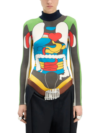 Person wearing a colorful, abstract-patterned long-sleeved top with black pants by Jean Paul Gautier