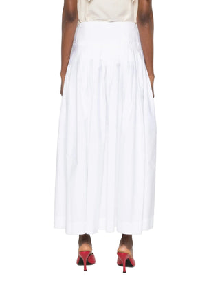 Person wearing a white pleated skirt with red high heels