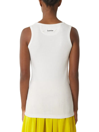 Woman wearing a white sleeveless top with 'LANVIN' branding and yellow skirt