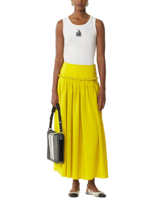 Person wearing a white sleeveless top and yellow skirt holding a black handbag 