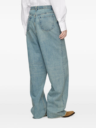 Light blue jeans worn with dropped rise and five pockets 