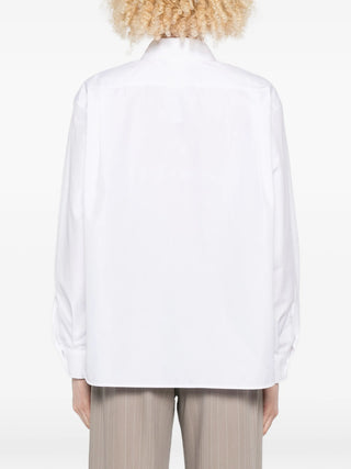 Person wearing white Max Mara pocket layered shirt from the back. 