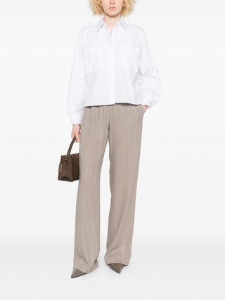 White Max Mara pocket layered shirt styled with Brown pants.