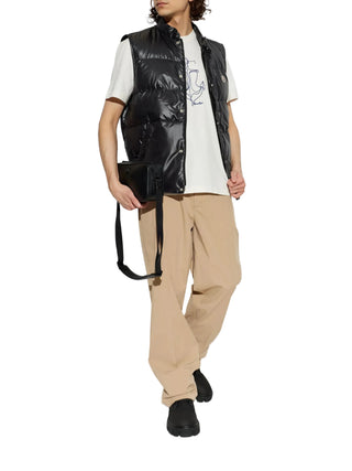 Person wearing a black puffer vest over a white shirt 