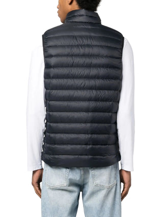 Person wearing a black puffer vest over a white shirt 