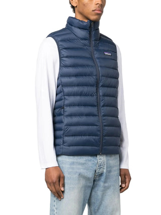 Person wearing a blue puffer vest with a visible brand logo by Patagonia