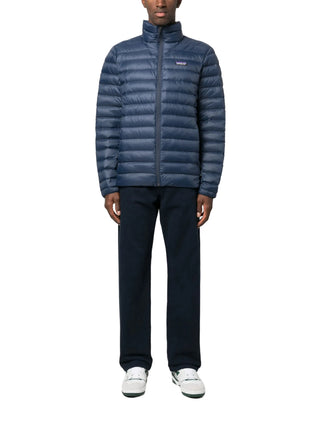 Person wearing a blue puffer jacket by Patagonia with pants and white shoes 