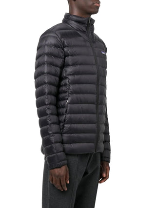 Person wearing a black puffer jacket with a Patagonia logo 