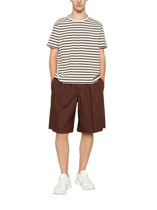 Person wearing a striped shirt and brown shorts by Plan C