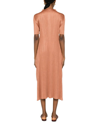 Person wearing a long, brown dress with pleats by Pleats Please Issey Miyake