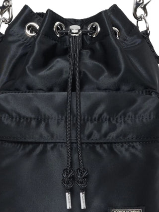 Close-up of a black drawstring bag with metal grommets and a brand label by Porter-Yoshida and Co. 