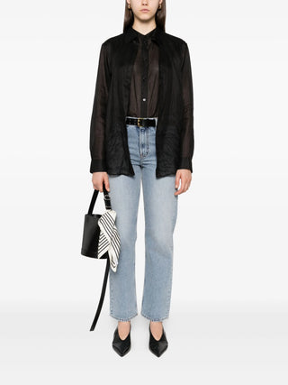 Person wearing a black shirt, light blue jeans, and holding a black handbag 